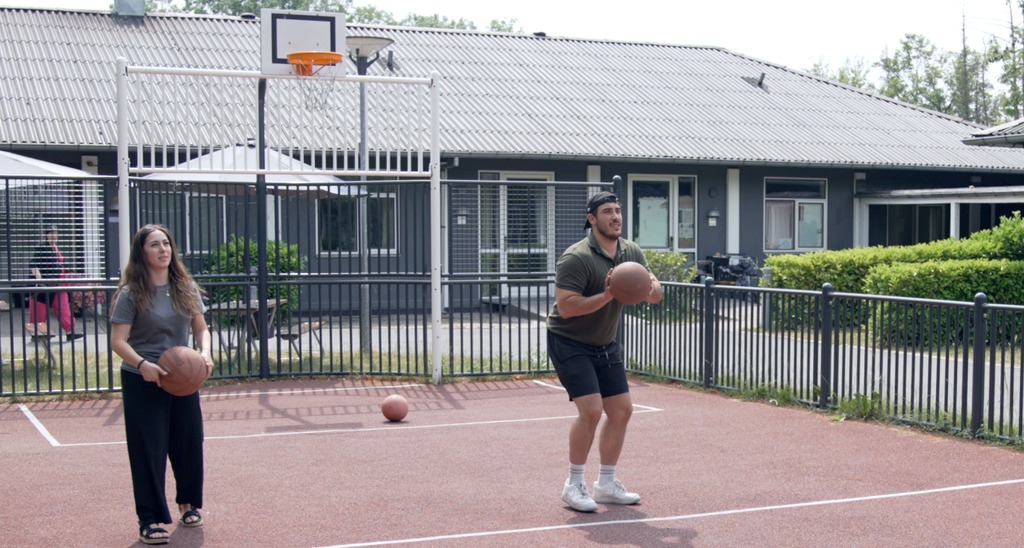 Billedet viser mennesker der spiller basketball på SKovvængets multibane