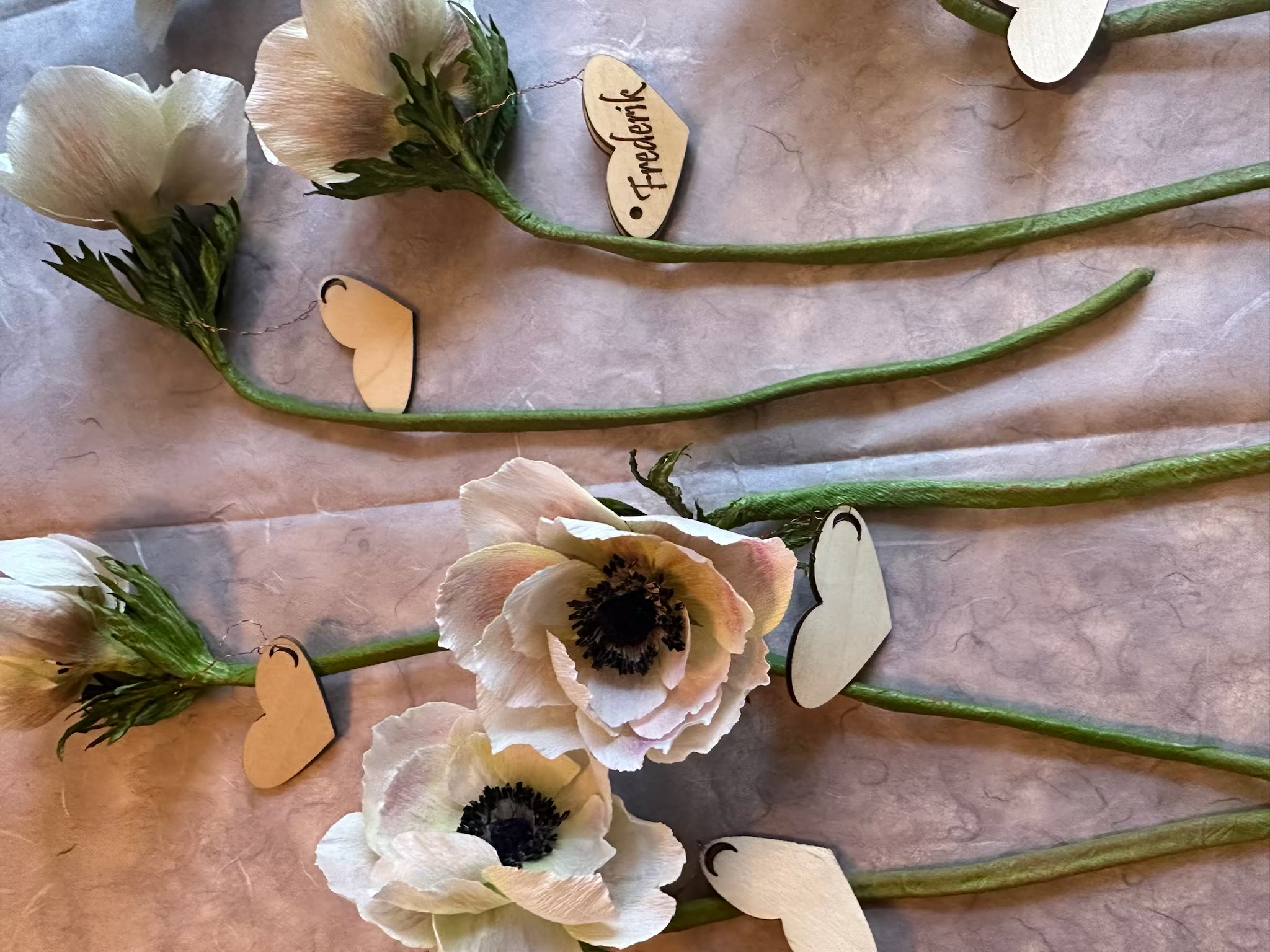 De fine papirsblomster lavet af Marita Hedegaard,  og små hjerteformede træskilte lavet på Bredegaard.