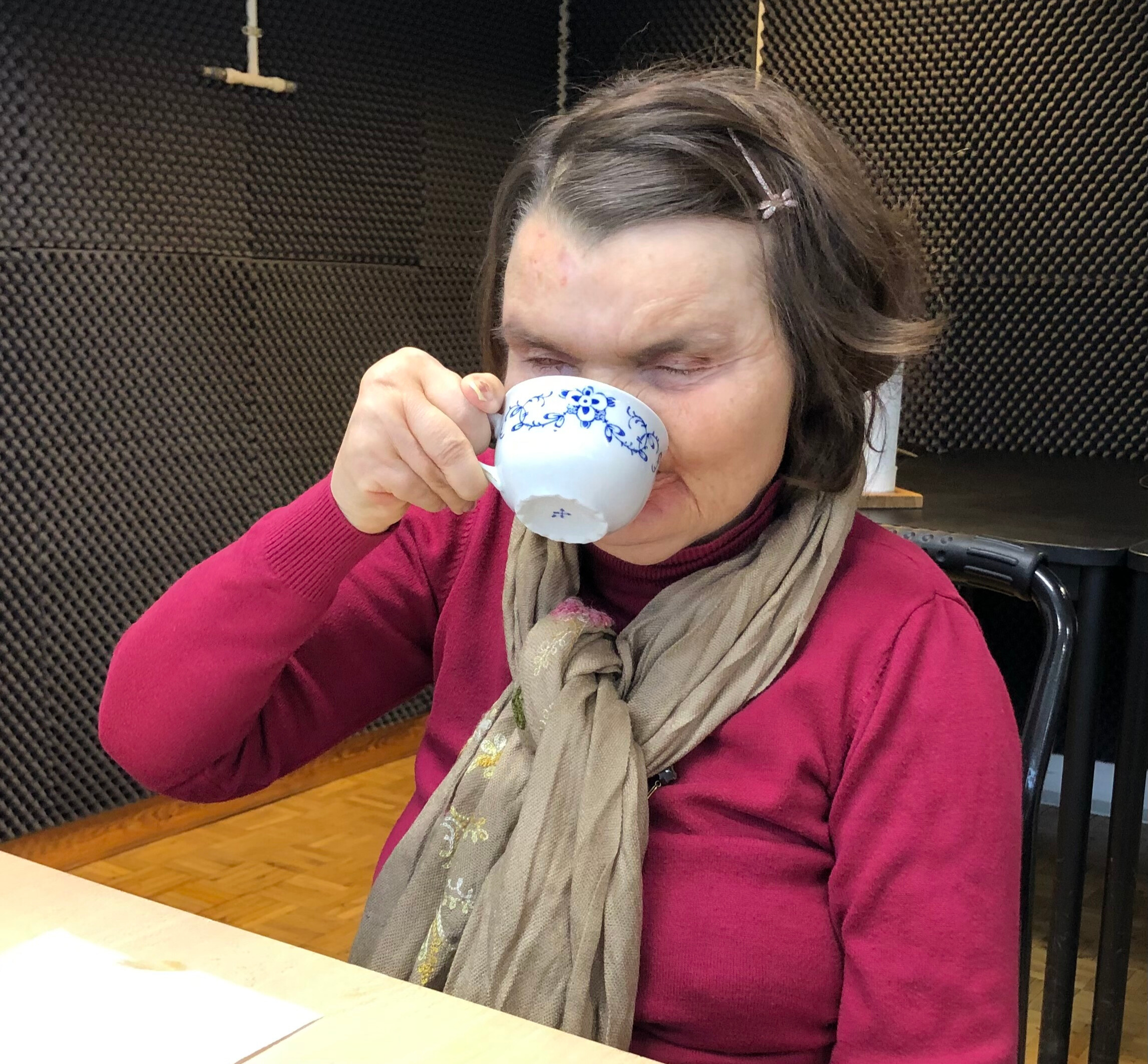 Lone tager en tår kaffe af det fine kaffestel. 