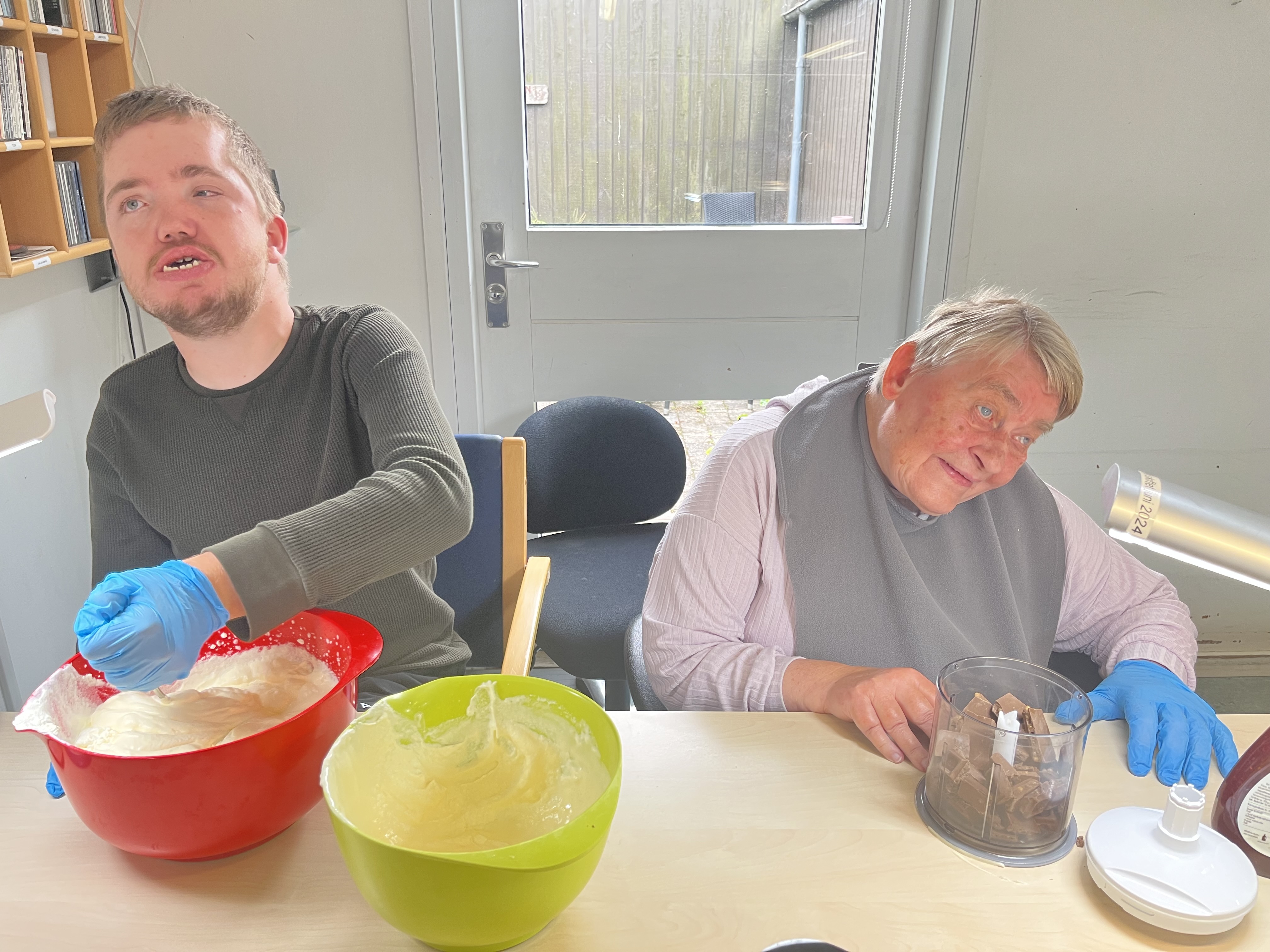 Jacob rører i flødeskummet og Ingelise hakker chokolade.