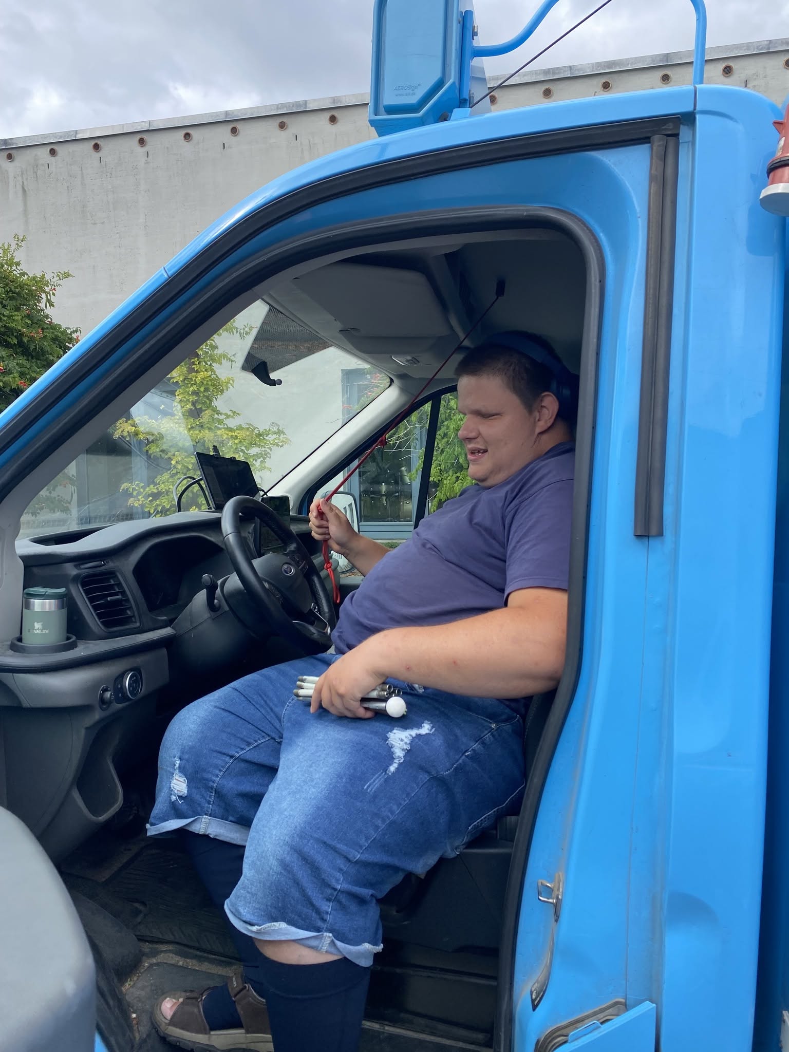 Nicholas på førersædet i Hjem-Is-bilen mens han hiver i klokke-snoren.