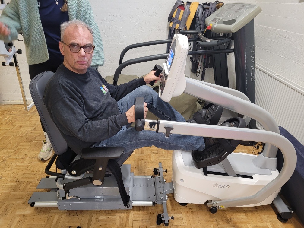 Erik træner i den siddende stepper, som står i samværs- og aktivitetstilbuddet.