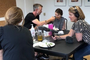 Billedet viser Lone i en spisesituation i dagtilbuddet sammen med Lars. Ninasofie og journalisten er også på billedet.