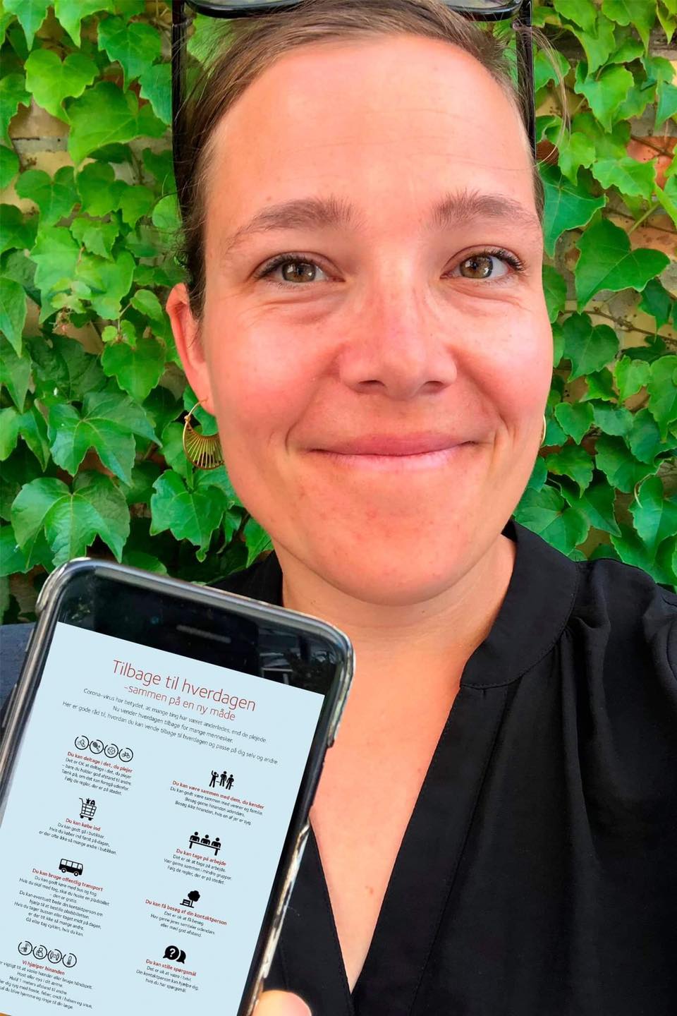 Social- og Indenrigsminister Astrid Krag viser guiden frem på sin mobiltelefon