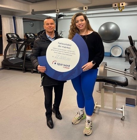 Direktør i Spar Nord i Helsingør Piet Petersen og Bredegaards fysioterapeut Marie Küchenthal Bjernøe Petersen med donationschecken i hånden. 
