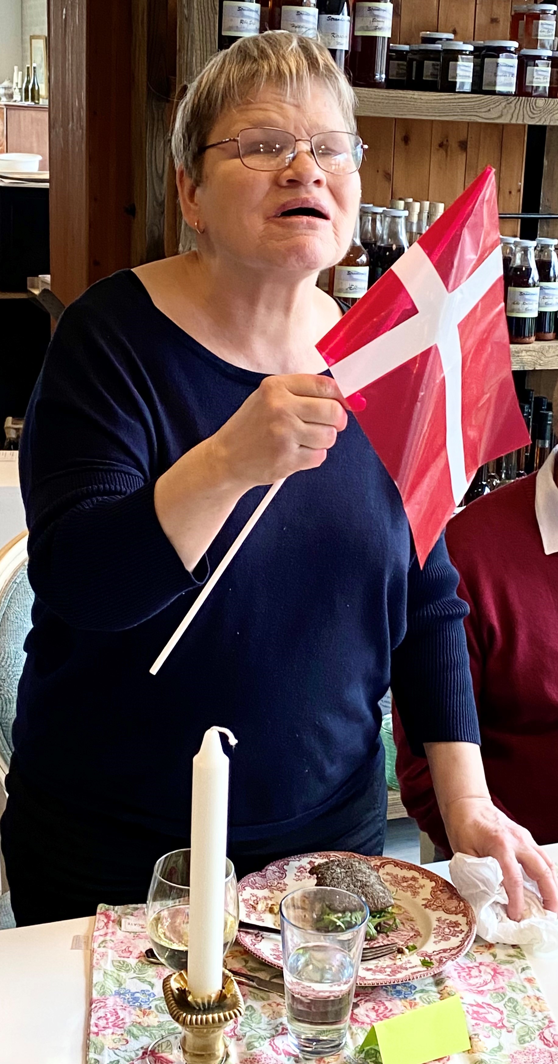Ulla med flag i hånden til 70-års fødselsdag hos René Wolf. Ulla holdt en tale og sang for på fødselsdagssangen. 