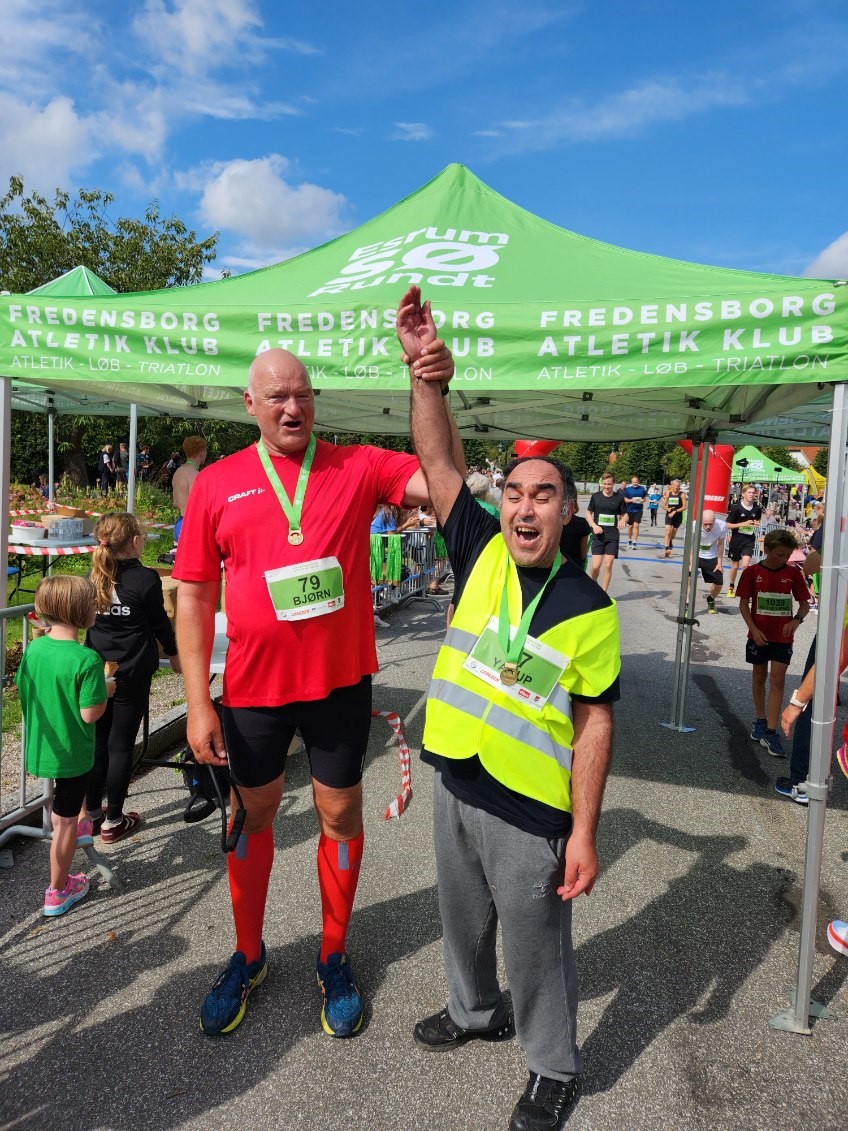 Ykaup og Bjørn er glade i mål efter 5 km. Yakup rækker sin ene hånd i vejret til sejr. 